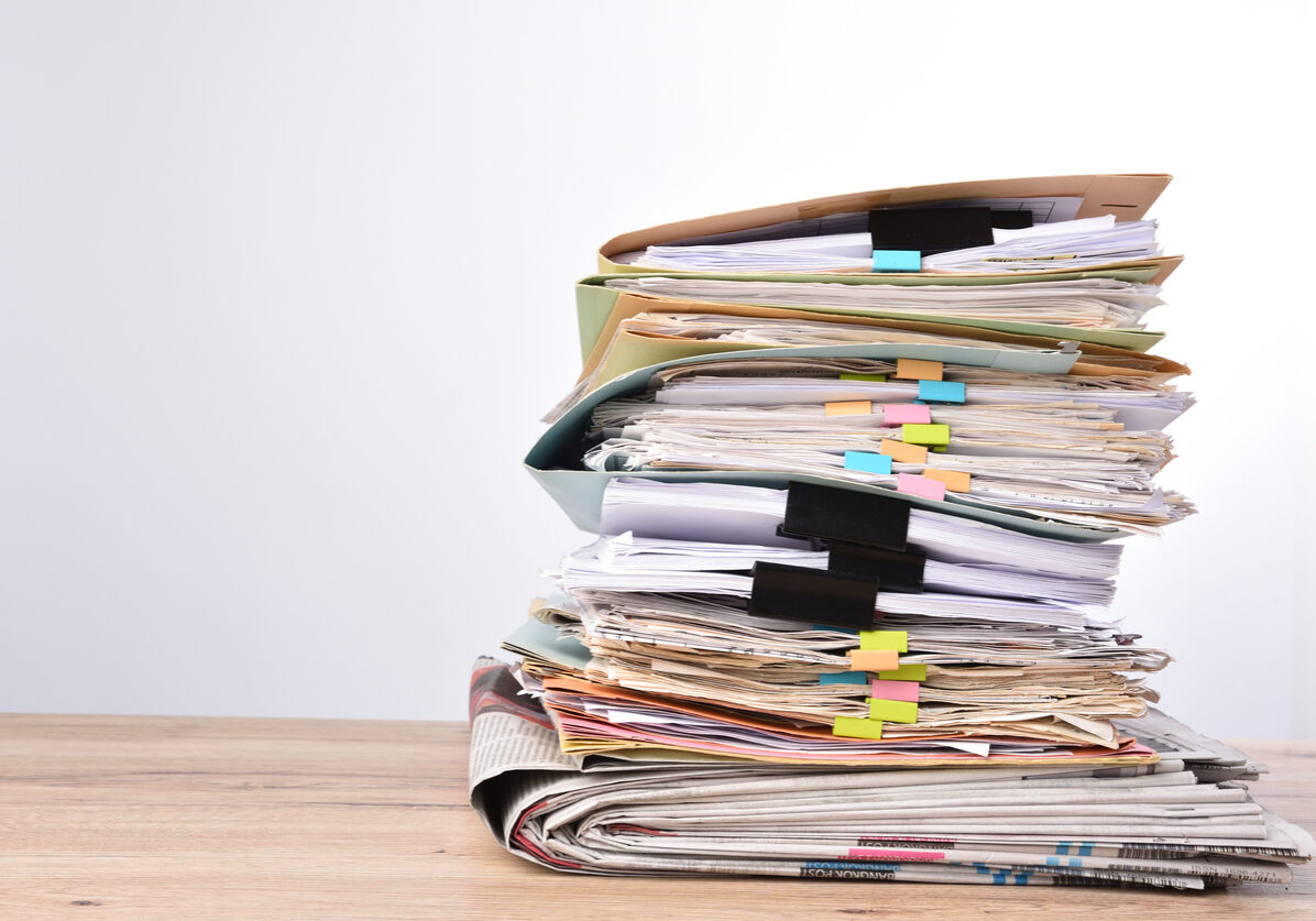 Stack documents pace on wood desk in office